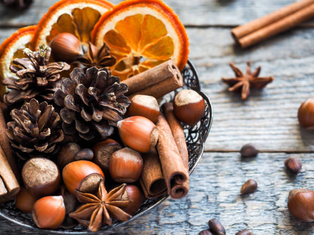 istock Winter ingredients nuts, cones, oranges, cinnamon star anise in a bowl. Rustic style 866645078