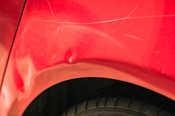istock Dented fender of red car close-up 866651536