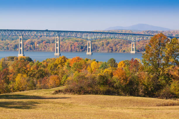 istock Kingston–Rhinecliff Bridge over Hudson River, Trees in Fall Colors (Foliage) and Blue Sky as seen from Poets' Walk, Red Hook, Hudson Valley, New York. 866655314