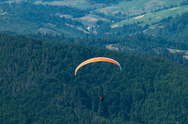 istock Paraglider flies over a mountain valley on a sunny summer day. 866657732