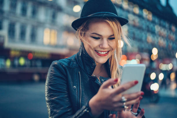 istock Smiling girl texting outdoors  in the evening 866660670
