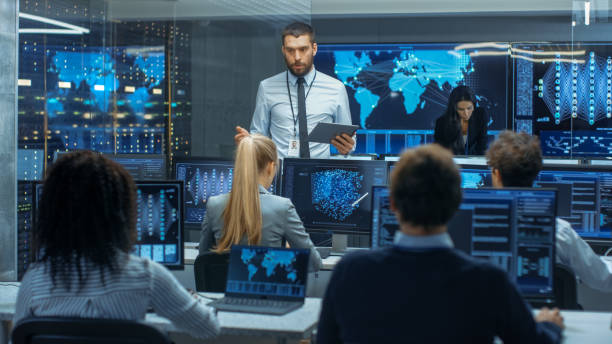 istock Chief Project Engineer Holds Briefing for a Team of Scientists that are Building Machine Learning System. Displays Show Working Model of Neural Network. 866661490