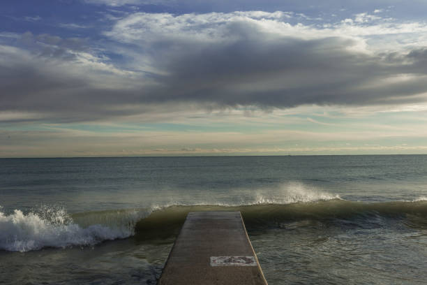 istock Concrete landing leading to lake as wave crashes 866676024