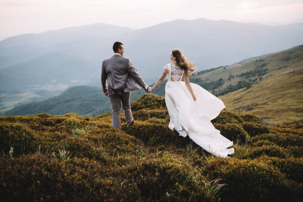 istock Romantic couple standing together holding hands in the mountains 866680012