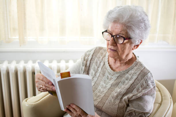 istock Senior woman reading book at home. 866680724
