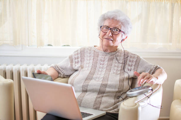 istock Senior woman using modern technology, smart phone, laptop and CD player with earphones. 866681168