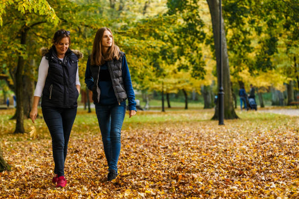 istock Two women walking in city park 866688520