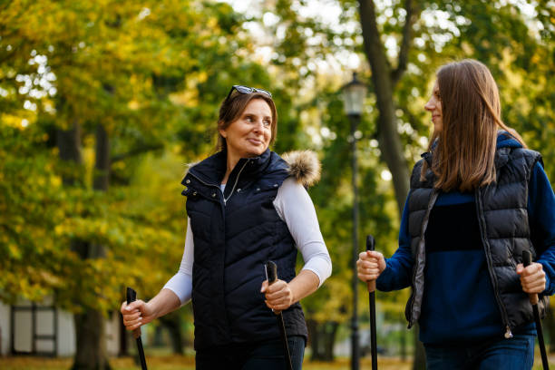 istock Two women walking in city park 866692782