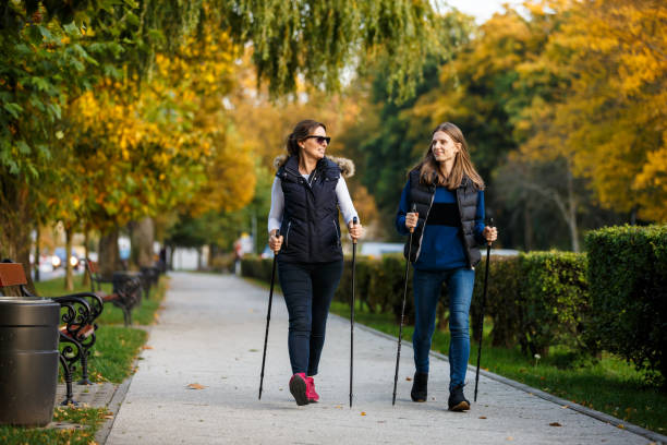 istock Two women walking in city park 866692886