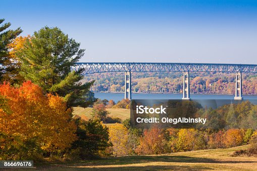 istock Kingston–Rhinecliff Bridge over Hudson River, Trees in Fall Colors (Foliage) and Blue Sky as seen from Poets' Walk, Red Hook, Hudson Valley, New York. 866696176