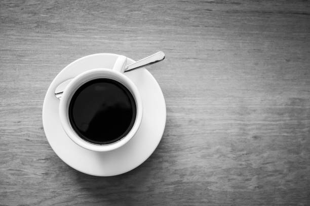 istock Coffee cup on wooden table. Black and White tone. 866696316