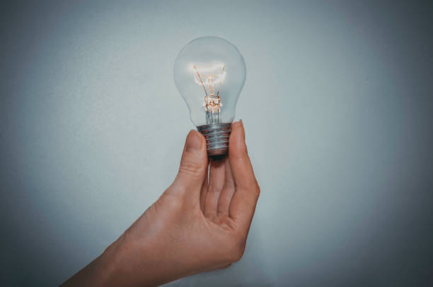 istock Young women hand holding a light bulb, lightning. creativity concept 866699520