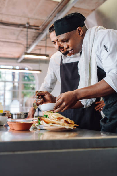 istock Chefs preparing food together in restaurant kitchen 866699558