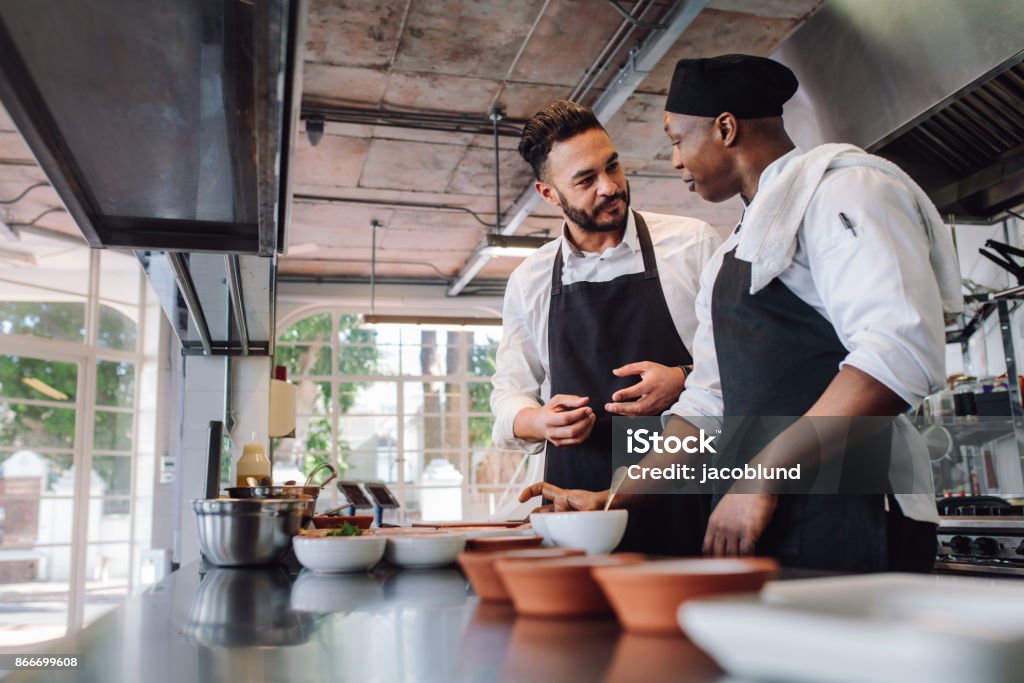 Hablando durante la cocción de alimentos en cocinas de chefs - Foto de stock de Chef libre de derechos