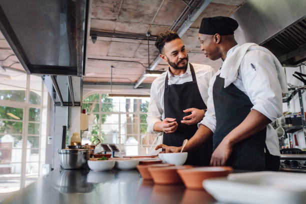 シェフの厨房で調理しながら話して - chef cooking restaurant food service occupation ストックフォトと画像