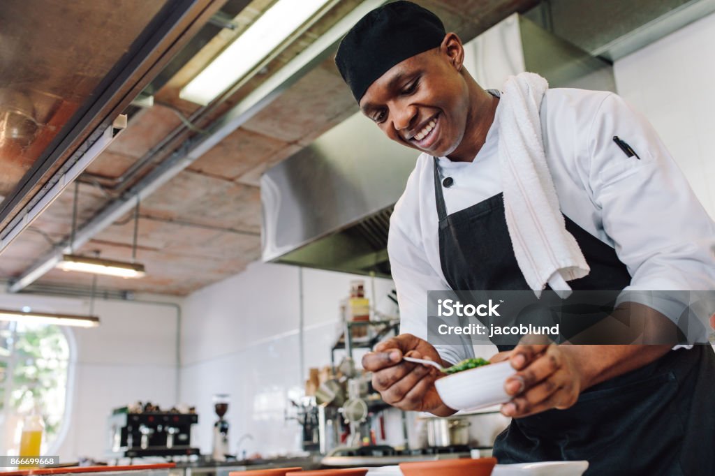 Chef gourmet che cucina in una cucina commerciale - Foto stock royalty-free di Cuoco