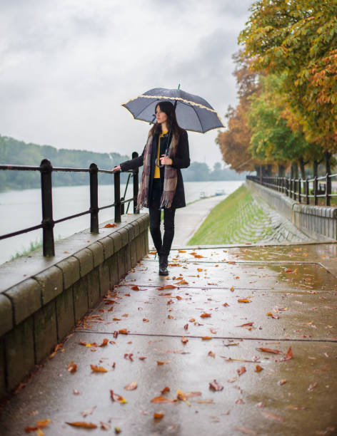 istock Young woman with umbrella walking in autumn rain 866707540