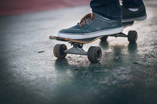 Young skateboarder girl in skate park having fun