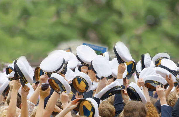 hands holding many swedish white graduation caps, green trees in the background - graduation student women beauty imagens e fotografias de stock