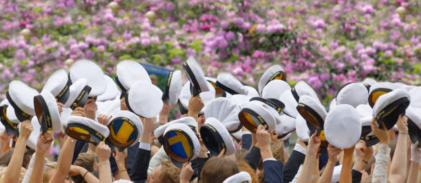 ręce trzymające wiele szwedzkich białych czapek w szkole tańca balettakademien w sztokholmie, szwecja, liliowe kwiaty w tle - high school student graduation education friendship zdjęcia i obrazy z banku zdjęć