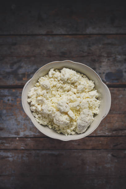 istock Fresh cottage cheese in a white bowl on a wooden surface 866729154