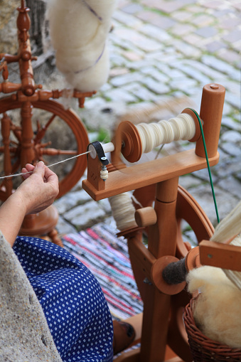 Hands working on a spinning wheel