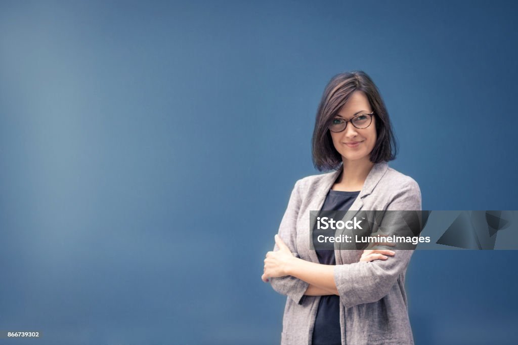 Portrait of confident businesswoman. Confident businesswoman with arms crossed. Portrait of successful freelance worker by the wall. Copy space. Women Stock Photo