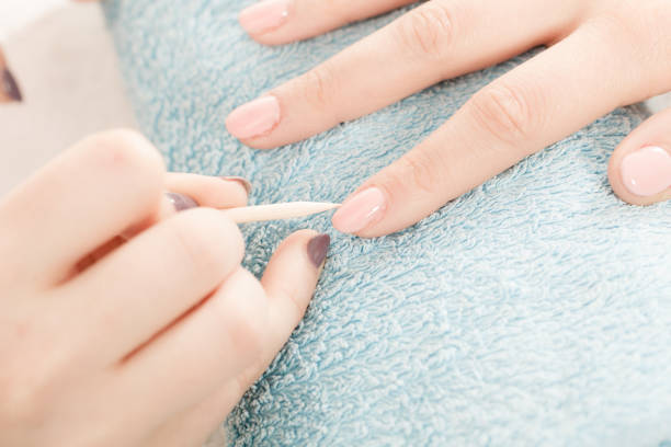 istock Beautician preparing nails before manicure, pushing back cuticles 866743292