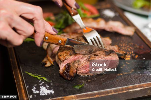 Woman Hand Holding Knife And Fork Cutting Grilled Beef Steak Stock Photo - Download Image Now