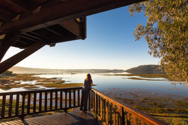 Mulher diverte Ver os com vista para Lagoa de Knysna, na África do Sul - foto de acervo