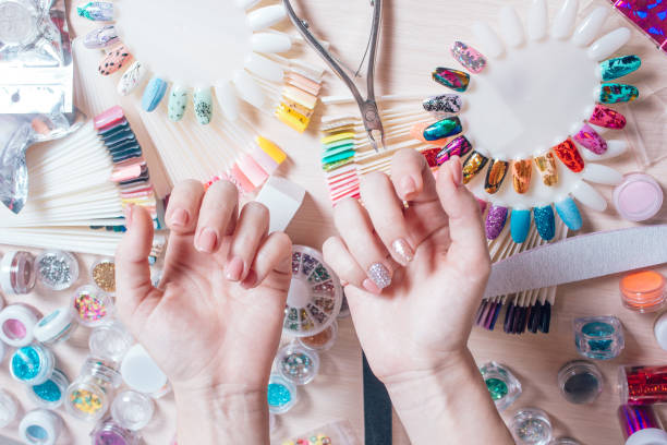 istock Nail art concept. Woman making decoration on the nails on white table 866754260