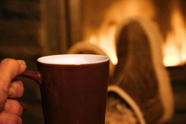 istock Feet in wool socks warming at the fireplace 866757060