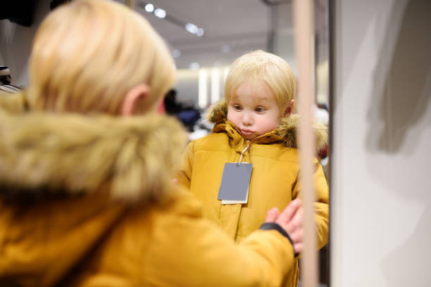 istock Cute little boy trying new coat during shopping 866764134
