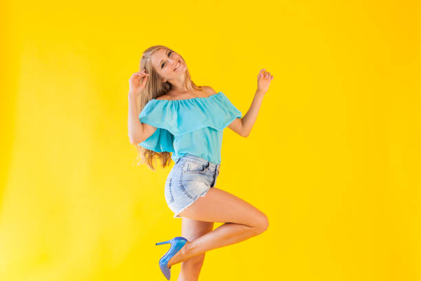 istock beautiful blonde with blue eyes posing on a yellow background 866765136