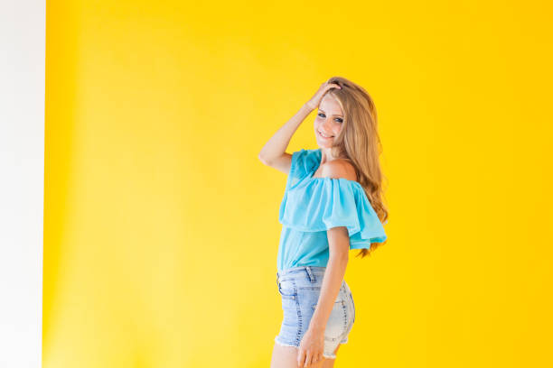 istock beautiful blonde with blue eyes posing on a yellow background 866765222