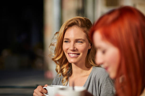 uśmiechnięta kobieta na kawę z przyjacielem - selective focus coffee coffee crop cafe zdjęcia i obrazy z banku zdjęć