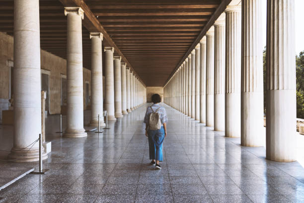 istock Young woman walking along the hall with classic Grek columns 866770990
