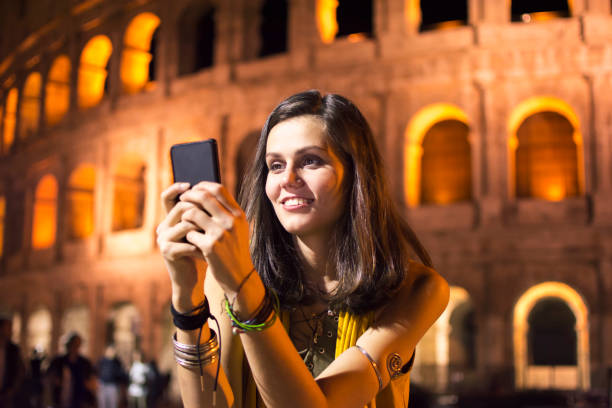 istock Smiling young woman using phone in Rome, Italy 866778522