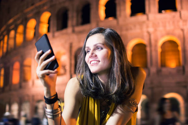 istock Smiling young woman using phone in Rome, Italy 866778538