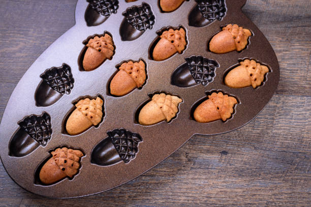 istock Maple Acorn Cakelets, acorn shape cookies in a baking pan, mold. Closeup. 866783070