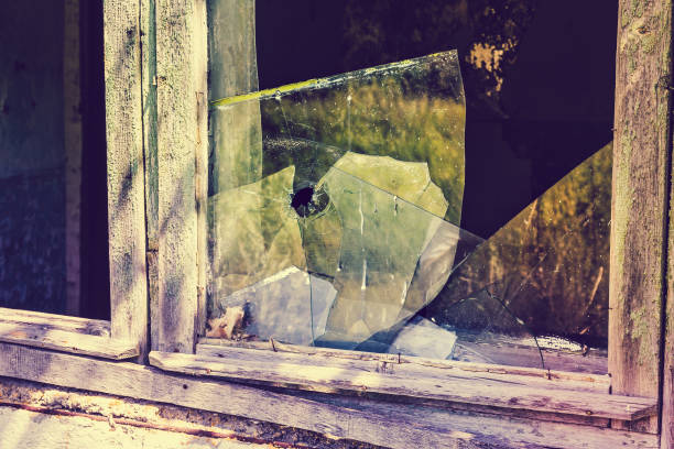 istock Broken window with broken glass. Bullet hole in the glass 866783622