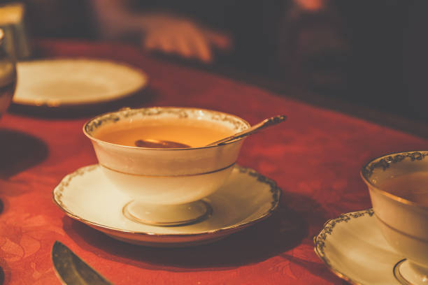 istock Cup of tea with spoon on red table, vintage style toned 866785946