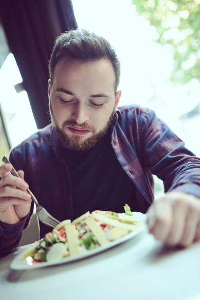 istock Young Smiling Man Eating Fresh Salad in the Morning 866789414