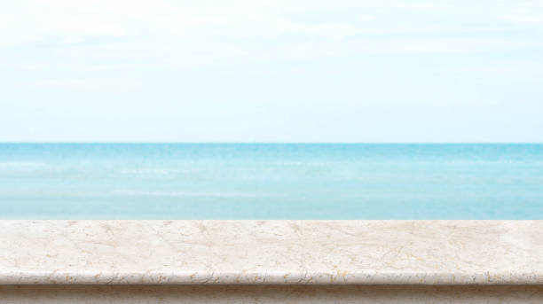 istock White marble table top with blurred bokeh sea and blue sky at background, Mock up template for display or montage of your product, Summer vacation concept,panorama view 866793022