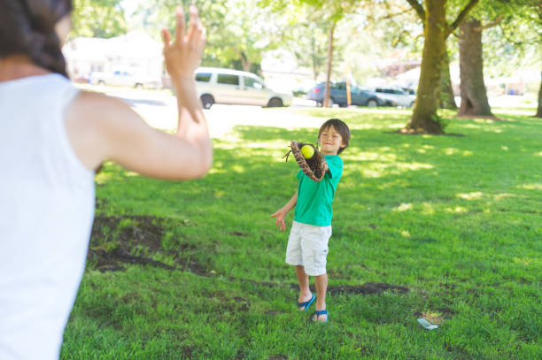 istock Mom and son play catch at the park 866793144