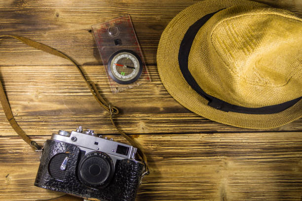 istock Compass, hat and retro photo camera on wooden background 866803712