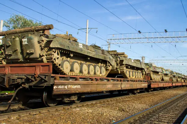 Cargo train carrying military tanks on railway flat wagons