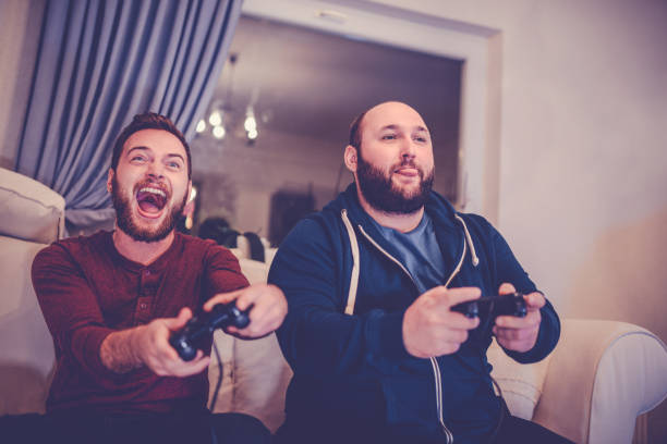 istock Two Excited Friends Playing Video Games 866804026
