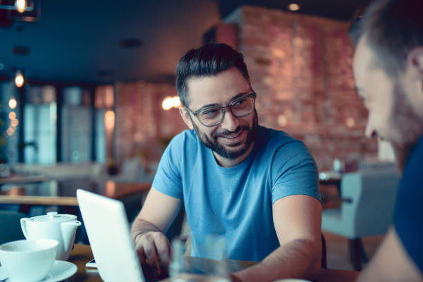 istock Two Handsome Friends Drinking Coffee and Surfing the Net In Cafe 866813266