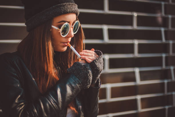 istock Young woman lighting a cigarette 866819508